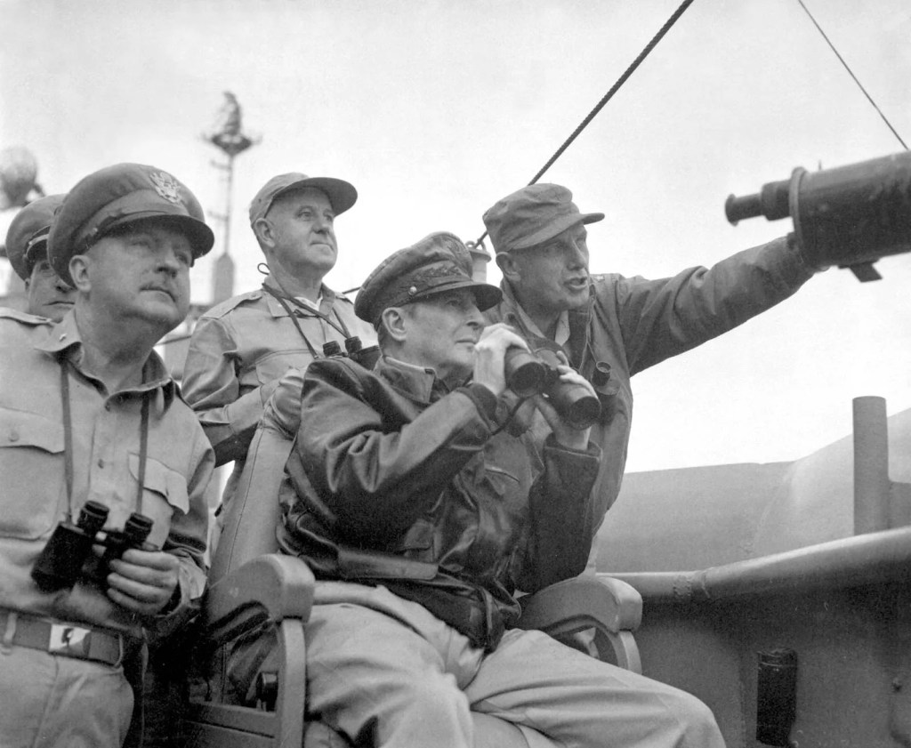 This image shows General Douglas MacArthur (center, holding binoculars) alongside his military staff during the planning and execution of the Incheon Landing on September 15, 1950, a pivotal operation during the Korean War. The successful amphibious assault, which MacArthur led, was a turning point in the war, allowing UN forces to recapture Seoul and reverse North Korea's early advances into the South.