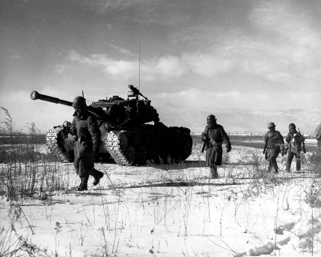 This image shows U.S. soldiers alongside a tank during the Korean War, moving through a snowy landscape. The harsh winter conditions, as depicted here, were a defining feature of the conflict, particularly during the Chosin Reservoir Campaign in late 1950. The image symbolizes the resilience of UN forces, despite facing extreme weather and difficult terrain, as they battled both North Korean and Chinese forces during one of the war's most intense phases.