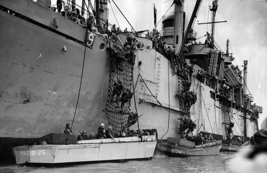 The image depicts troops disembarking from a ship into smaller landing craft during the Incheon landing operation in September 1950, a key moment in the Korean War. This amphibious assault, led by General Douglas MacArthur, was critical in turning the tide of the war in favor of the United Nations forces by recapturing Seoul and pushing North Korean forces back across the 38th parallel.